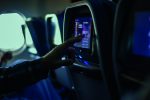 Passenger selecting a movie on touchscreen during airplane flight